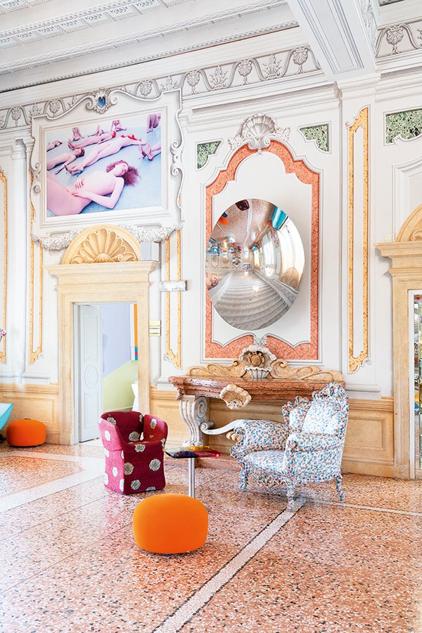 Lounge corner with artistic armchairs, convex mirror and photograph by Vanessa Beecroft
