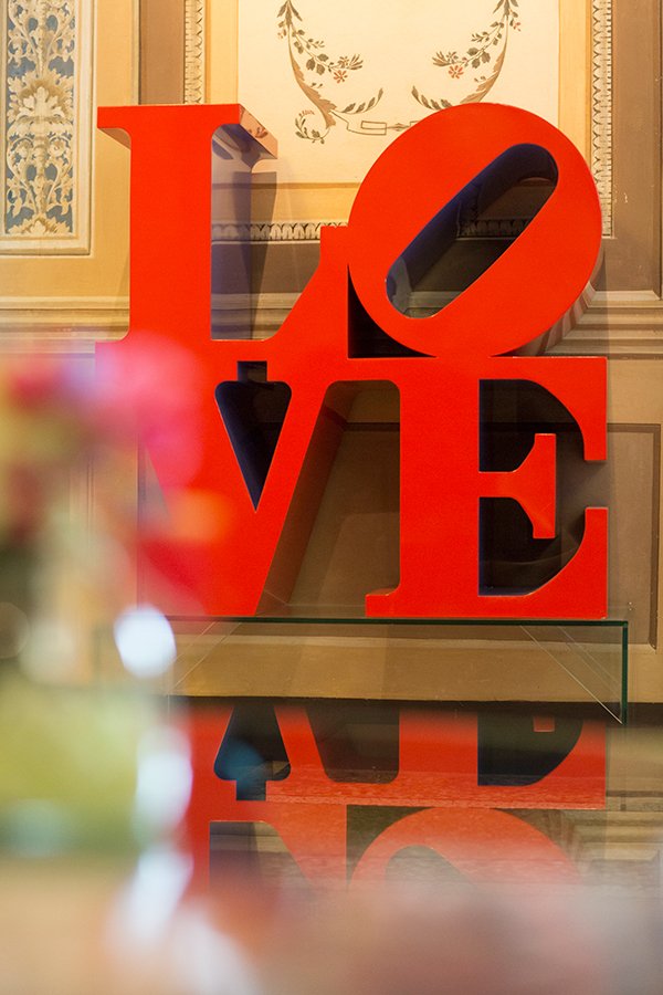 Scultura iconica LOVE di Robert Indiana in rosso brillante, all’interno di una sala del Byblos Art Hotel