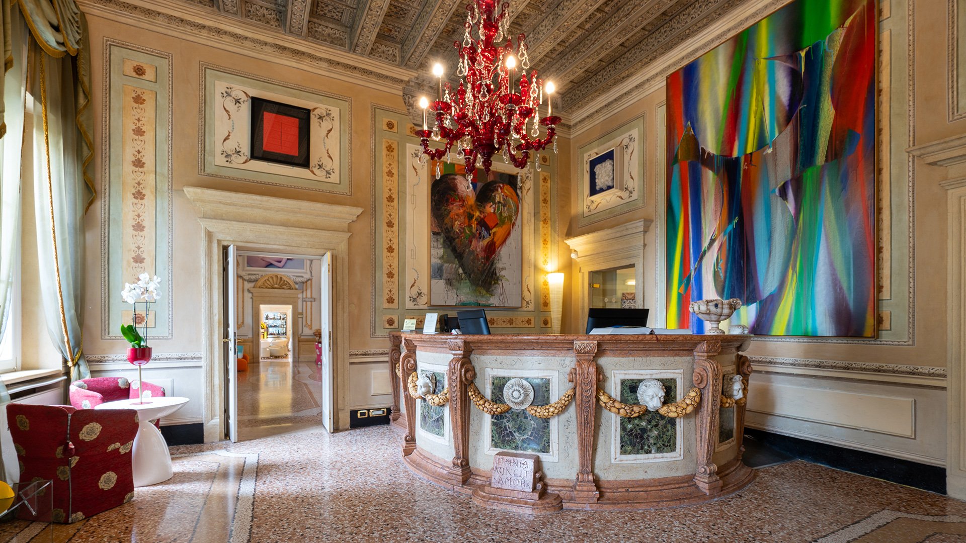 Angolo relax con il celebre divano a labbra rosso e opere d’arte pop nella Sala Millar del Byblos Art Hotel
