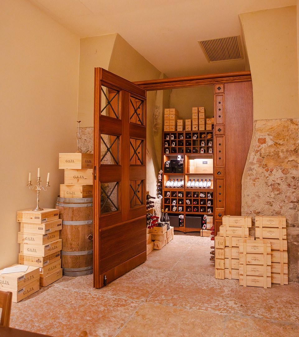 Cantina con bottiglie pregiate e casse in legno a vista
