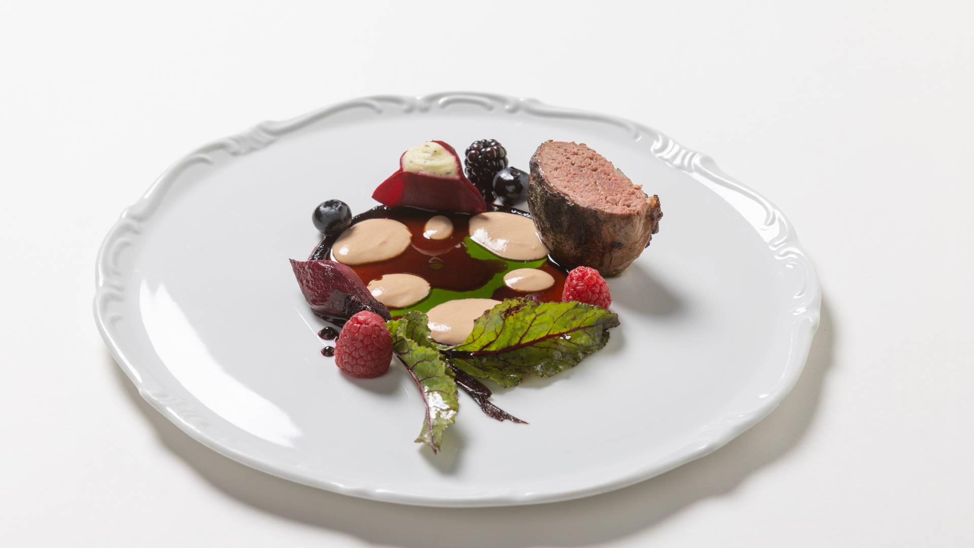 Piatto gourmet servito al Ristorante Amistà con anatra in crepinette, frutti di bosco patata alla maggiorana e rapa rossa