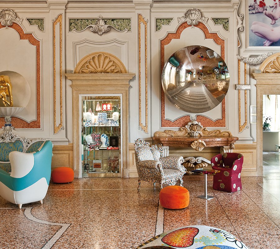 Hall of the Byblos Art Hotel with concave mirror by Anish Kapoor, colorful armchairs and eclectic design.