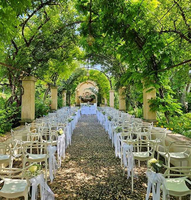 Outdoor wedding ceremony in the garden under flowered arches