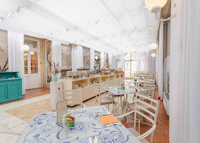 Bright conservatory with tables for breakfast or lunch