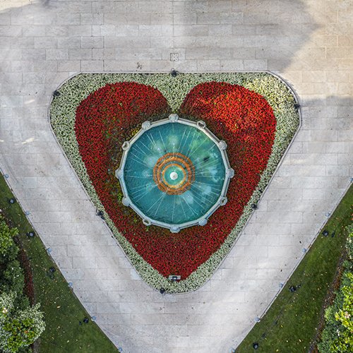Fontana centrale vista dall’alto con aiuola a forma di cuore nel giardino del Byblos Art Hotel