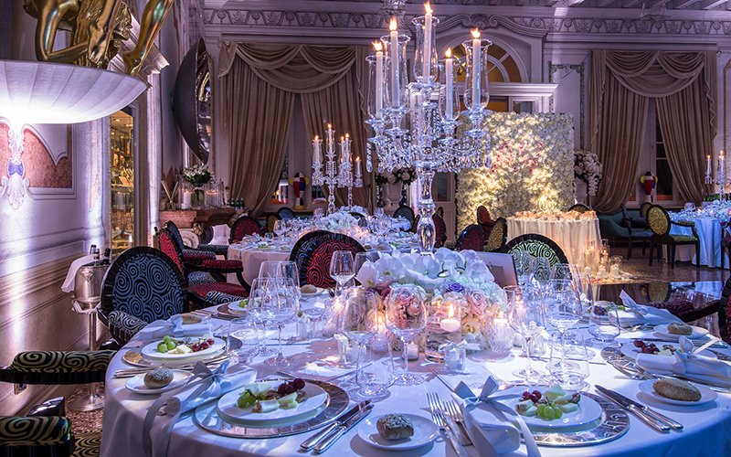 Stilvolles Setup für die Hochzeitsfeier in der Halle des Byblos Art Hotel mit Kronleuchtern und Blumenschmuck