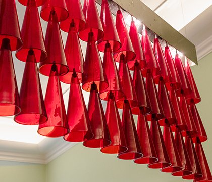 Light installation with red glasses hanging from the ceiling at Peter’s Bar