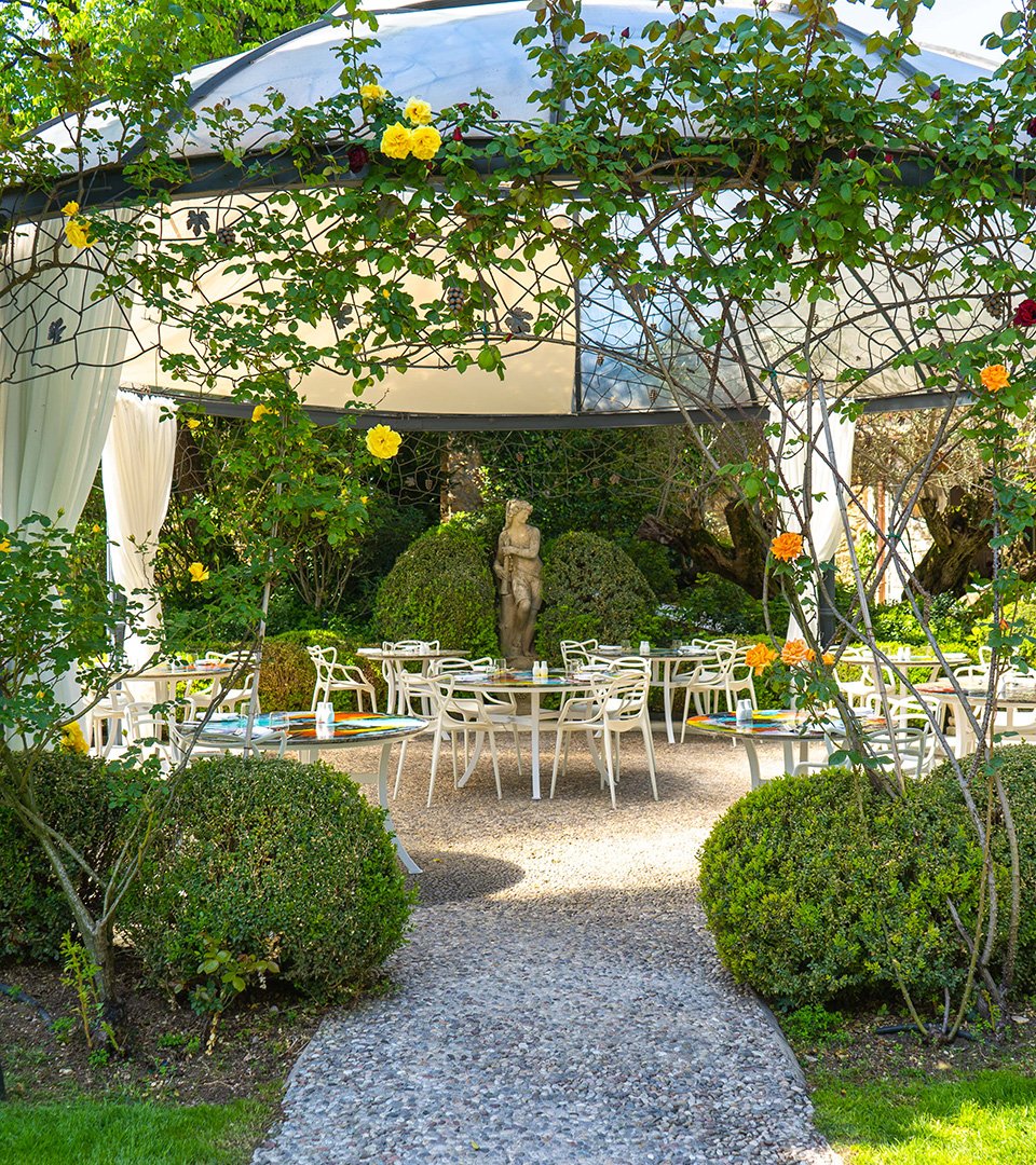 Chef working in the open-air show kitchen of Ristorante Saor, surrounded by greenery