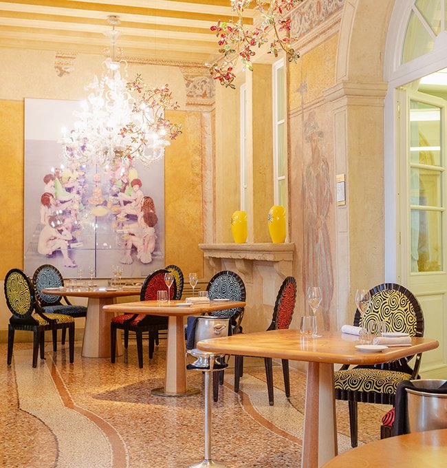 Elegant interior room at Ristorante Saor with designer chandelier and wall frescoes