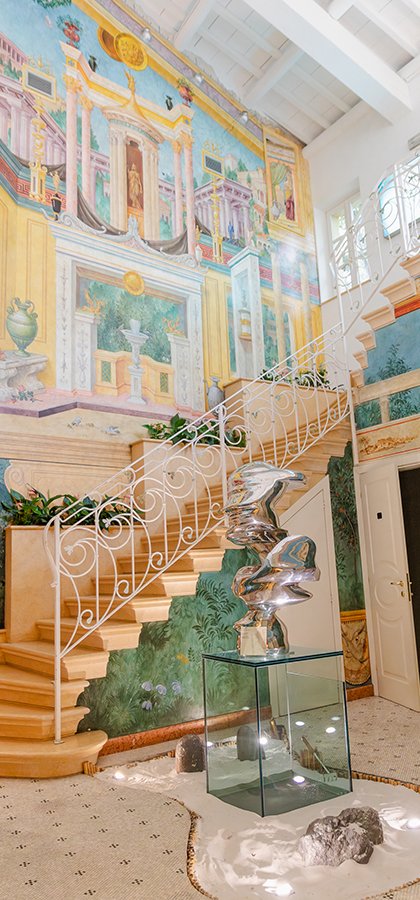 Dramatic staircase with frescoes and contemporary sculpture in glass and metal