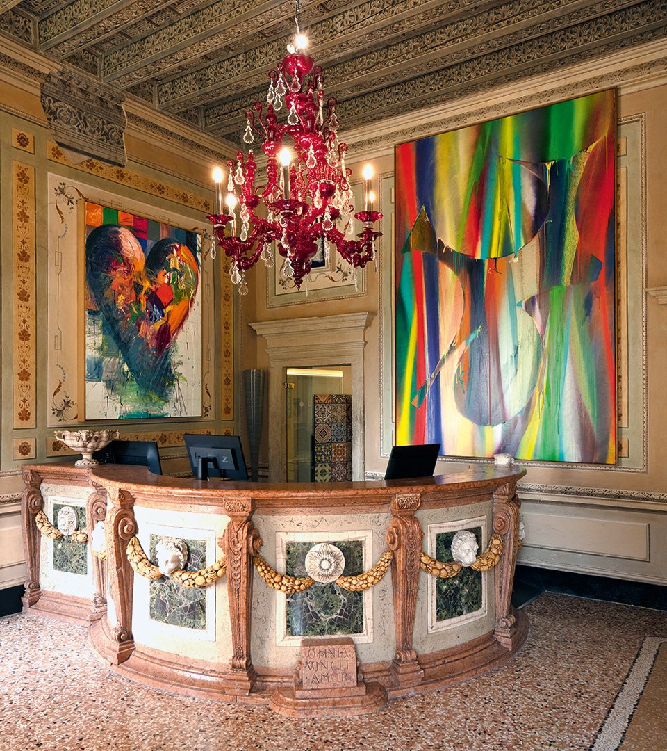Reception of the Byblos Art Hotel with marble counter, Murano glass chandelier and contemporary artworks